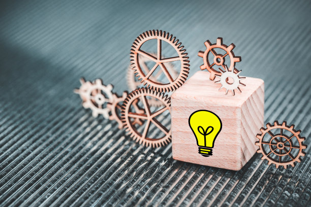 木块上的灯泡符号，发条齿轮和机构，创新和匠心的标志，创意企业发展，近距离图片下载