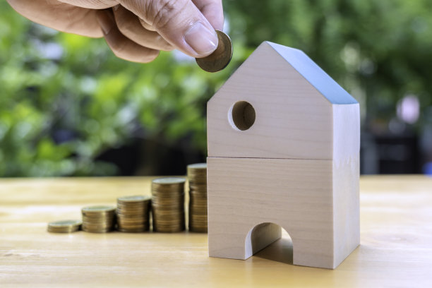 商人放钱或存钱的手，硬币和样板房。房地产投资和房屋抵押金融，房地产投资，税收和奖金的概念。图片下载
