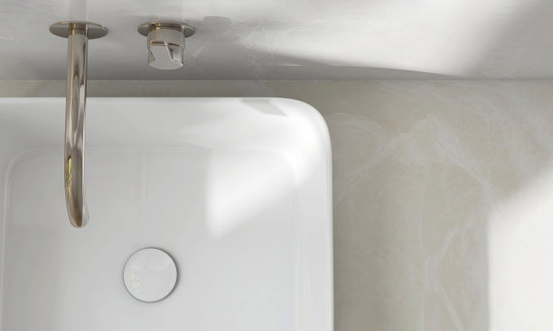 奶油大理石梳妆台面，白色现代矩形陶瓷洗脸盆，甲板安装铬水龙头在阳光和阴影的浴室图片下载