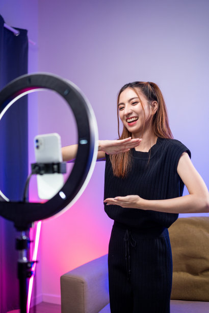 年轻的时尚影响者亚洲女人在家里的客厅里用霓虹灯跳舞。创作者，视频博主，才艺舞蹈，享受爱好，内容录制，展示视频分享在社交媒体上。图片下载