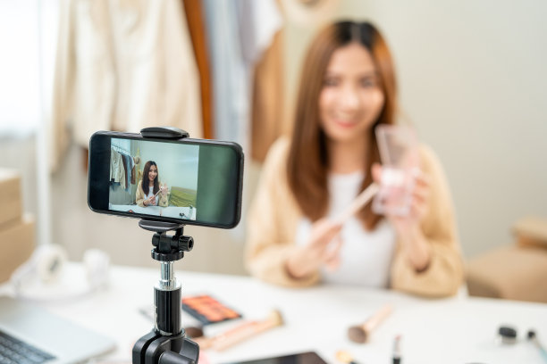 年轻美丽的亚洲女性视频博主直播化妆化妆教程内容与眼影看手机。网红专业美妆化妆品在社交上录制视频图片下载