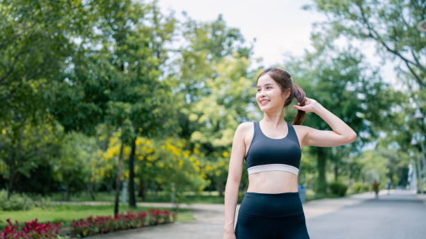 年轻女子穿着健身服在公园里锻炼的照片。健康的概念。图片下载