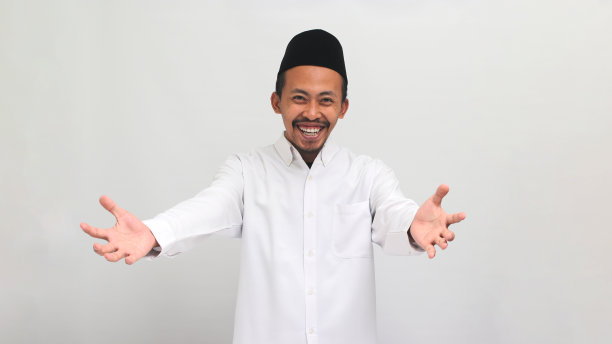 微笑着的年轻印尼男子用双手招手，表示欢迎，孤立在白色背景上图片下载