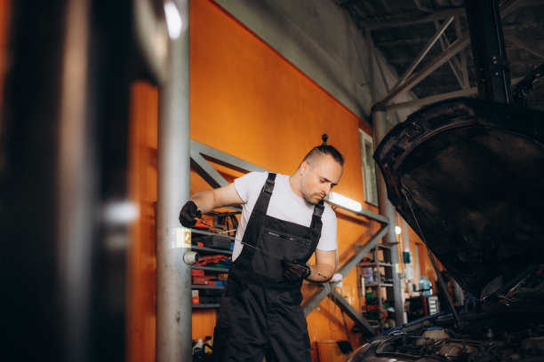 汽车修理工在维修中心检查发动机机油位。图片下载