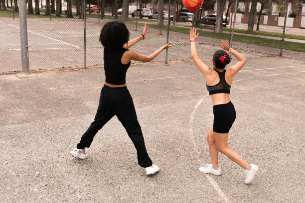 一个黑发的中国女孩和她的朋友在球场上打篮球-来自不同国家的人们打篮球的照片。图片下载