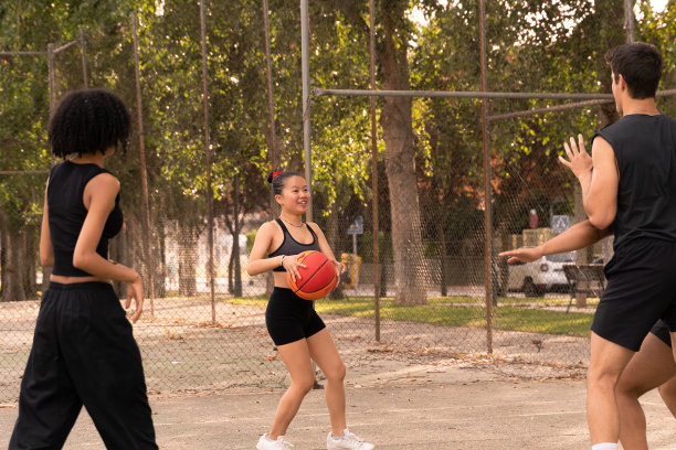 一个黑发的中国女孩和她的朋友在球场上打篮球-来自不同国家的人们打篮球的照片。图片下载