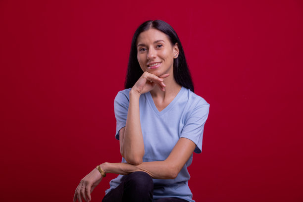 单身女人。美丽的东欧女人的肖像在红色的背景。图片下载