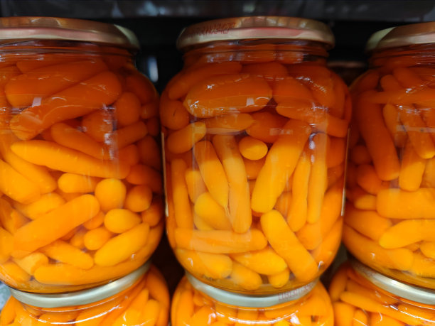 超市的货架上排列着没有标记的玻璃瓶，里面装着小胡萝卜图片下载