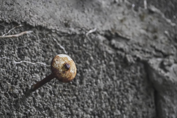锈迹斑斑的旧屋顶钉或嵌在混凝土砖(土坯)上的尖钉图片下载