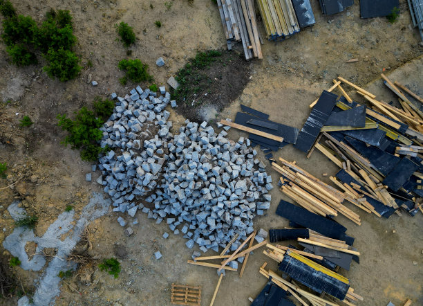 无人机拍摄的建筑工地。把木板和石瓦堆成一堆。在职业事故发生前没有时间清理的脏乱。以上，工作街道，桥梁维修，混凝土图片下载