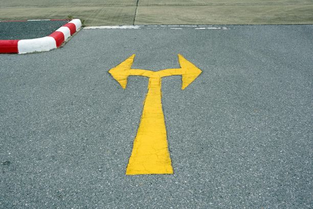 马路上有一个交通标志，马路上的沥青上有黄色的箭头。图片下载