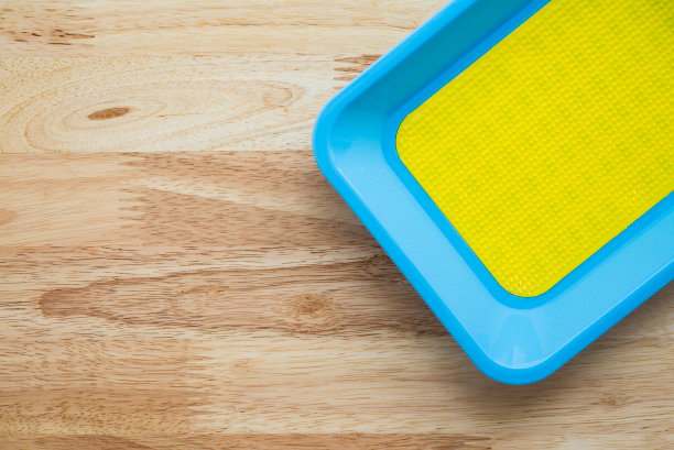 木桌上空空的彩色硬币盘。图片下载