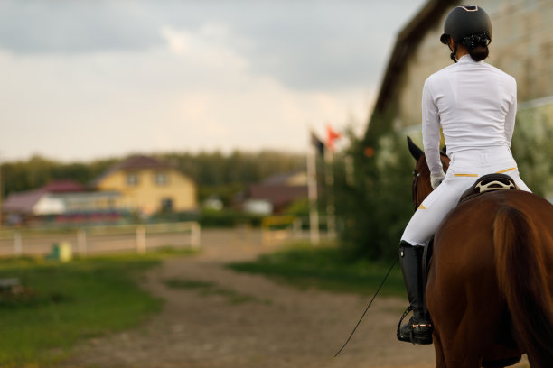 女骑手骑师戴头盔和白色制服准备赛马与复印空间。图片下载