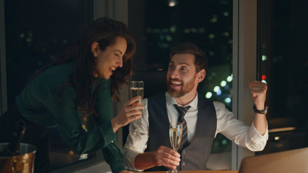 合伙人在办公室喝香槟庆祝生意上的成功，直到深夜。图片下载