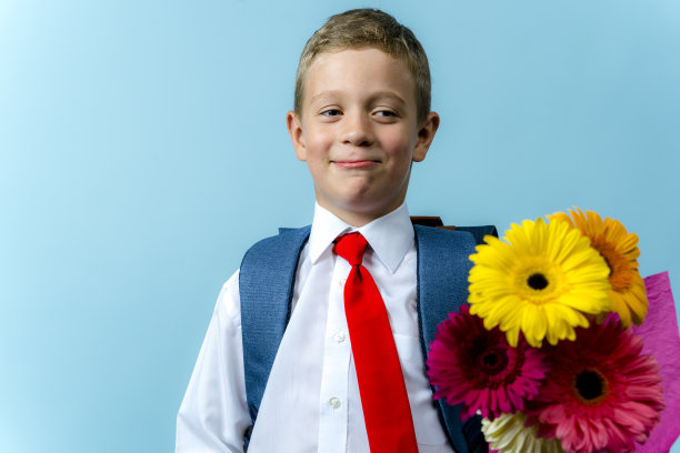 一个背着书包的一年级学生拿着一束花图片下载