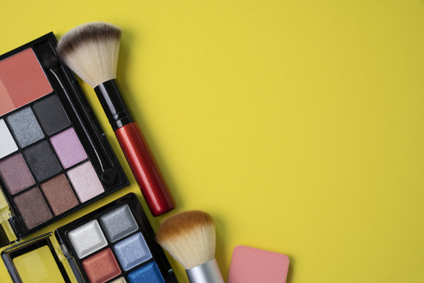 黄色桌面上的一组彩色化妆品图片下载