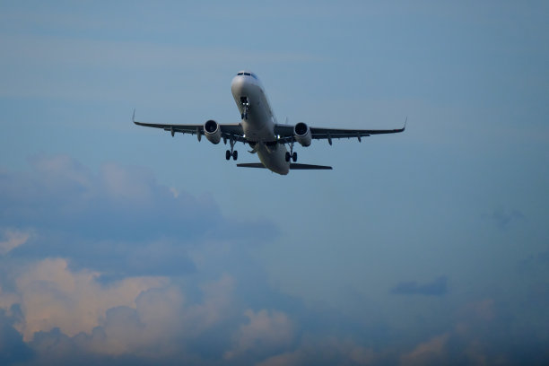 一架飞机在晴朗多云的天空中从跑道上起飞。图片下载