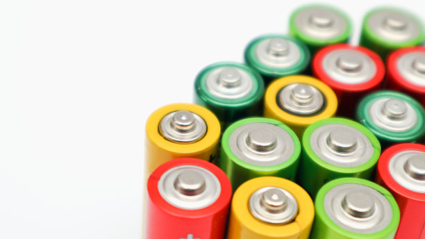 白色背景上不同颜色的电池。电池正极特写，选择性聚焦。回收用过的电池。危险垃圾概念图片下载