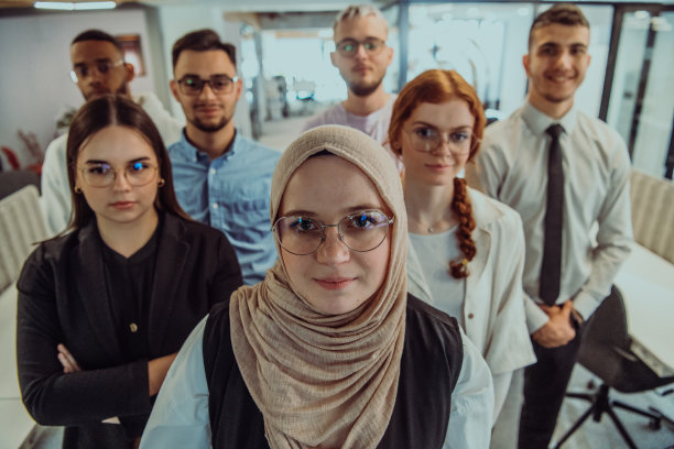 一群年轻的商务人士站在一起，从繁忙的工作日中休息一下，展示同志情谊，团队合作，在充满活力的工作场所放松一下图片下载