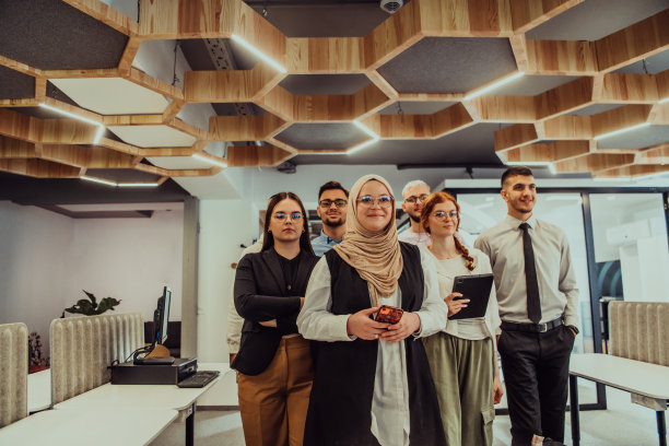 一群年轻的商务人士站在一起，从繁忙的工作日中休息一下，展示同志情谊，团队合作，在充满活力的工作场所放松一下图片下载