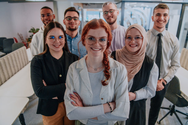 一群年轻的商务人士站在一起，从繁忙的工作日中休息一下，展示同志情谊，团队合作，在充满活力的工作场所放松一下图片下载