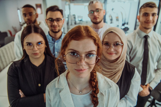 一群年轻的商务人士站在一起，从繁忙的工作日中休息一下，展示同志情谊，团队合作，在充满活力的工作场所放松一下图片下载