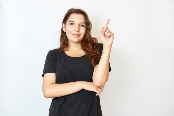 漂亮女孩用食指举起手。注意和谨慎的概念。图片下载