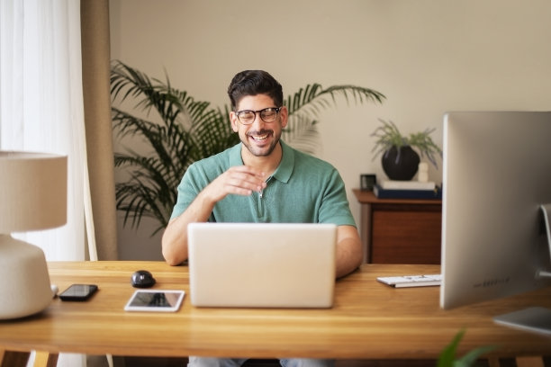 自信的商人坐在办公桌前，带着笔记本电脑，在家工作图片下载