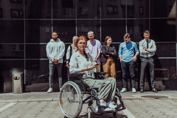 一群多元化而自信的年轻商人聚集在一起，轮椅上的女商人散发着成功、雄心和团结的光芒，捕捉了一个充满活力和鼓舞人心的商业环境的精髓图片下载