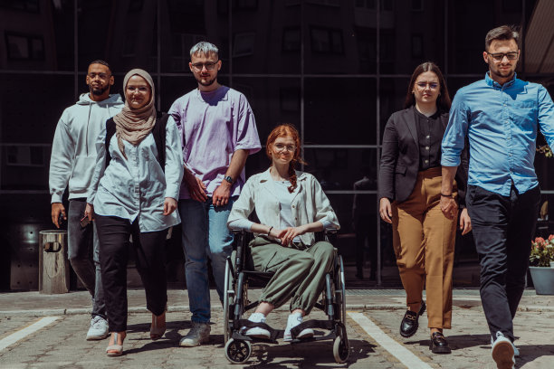 一群多元化而自信的年轻商人聚集在一起，轮椅上的女商人散发着成功、雄心和团结的光芒，捕捉了一个充满活力和鼓舞人心的商业环境的精髓图片下载