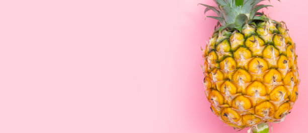 粉红色背景上的新鲜菠萝。图片下载