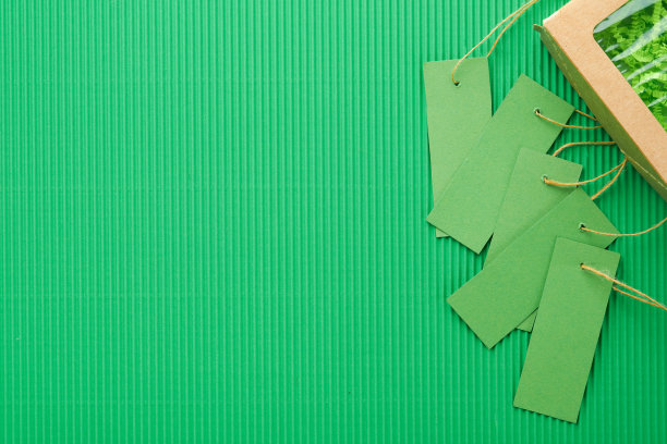 绿色星期五的背景模拟。绿色背景的销售标签。纸质购物盒和绿色标签。环保购物理念，有用的东西打折。减少过度消费。图片下载
