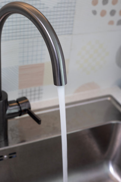 水从不锈钢水龙头流出。厨房的房间图片下载