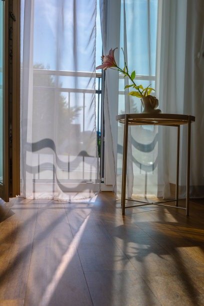 现代的房间内部，以最小的风格打开窗户。透明薄纱与早晨的阳光阴影背景图片下载