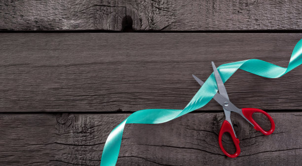 剪子在木面上剪丝带的俯视图。图片下载