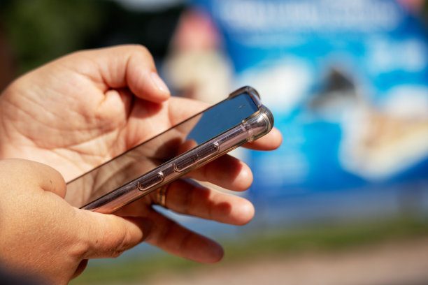 一个人正在使用蓝色背景的智能手机。图片下载