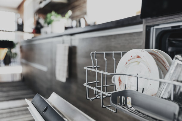 在晚餐或午餐后用脏餐具打开厨房的洗碗机图片下载