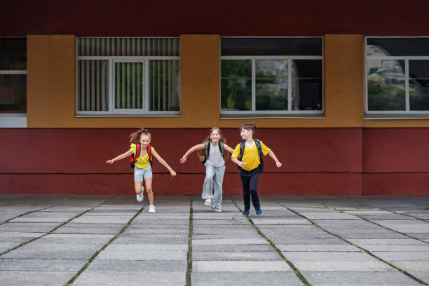 学童们从学校跑出来。同学们背着书包。回到学校。图片下载