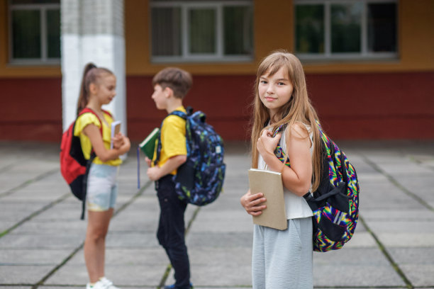 在户外拿着书和背包的女学生。回到学校。开始上课。图片下载