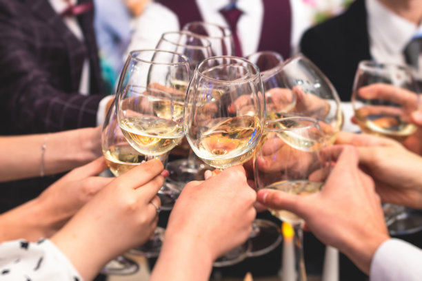 在公司的圣诞生日聚会或婚礼庆典上，宾客们在餐厅里举杯庆祝，用酒杯和香槟欢呼图片下载