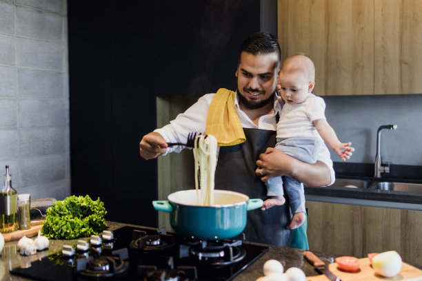 拉丁美洲，拉美裔年轻家庭，拉丁裔单身父亲和小儿子在厨房做饭图片下载