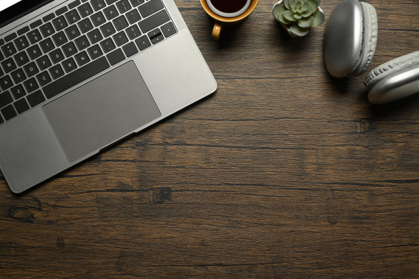 简单的工作空间，有笔记本电脑、无线耳机和木桌上的一杯咖啡图片下载