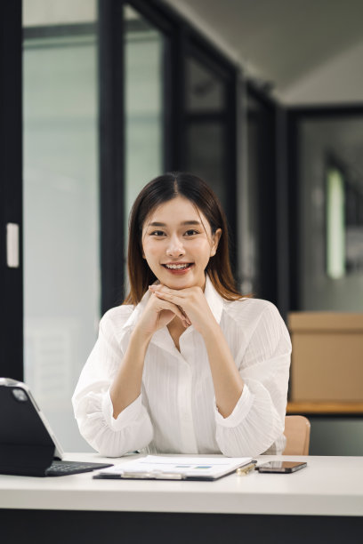 女商人坐在办公椅上放松地看着镜头。图片下载