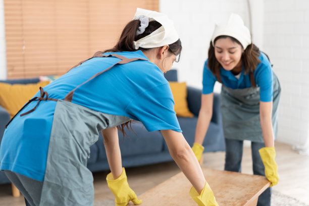快乐的亚洲妇女穿着工作服女仆在家里抬桌子图片下载