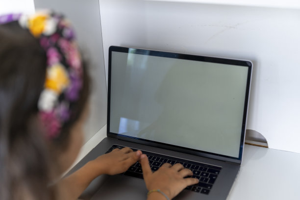 一个正在学习的女孩。小学生用电脑学习。女学生在家做作业。回到学校。图片下载