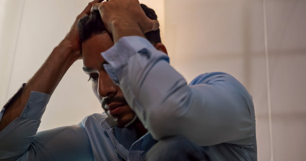 一个商人坐在地板上，因为生活中的问题而感到沮丧和压力。图片下载