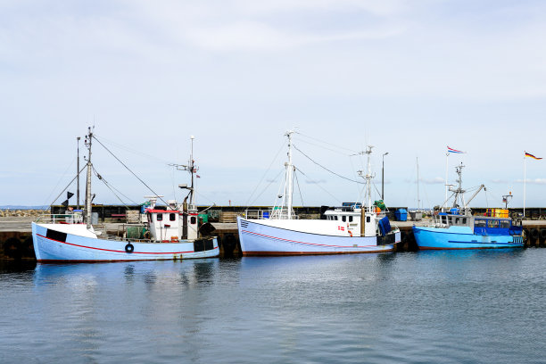 三艘小渔船停泊在港口码头图片下载