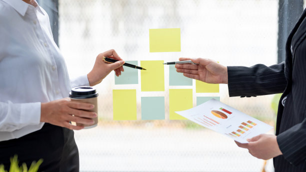 商务人士咨询投资项目工作和营销策略规划，并使用计算器和文件。图片下载