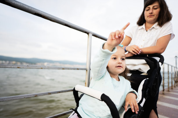 母亲和女儿在保加利亚阳光海滩的堤岸。图片下载