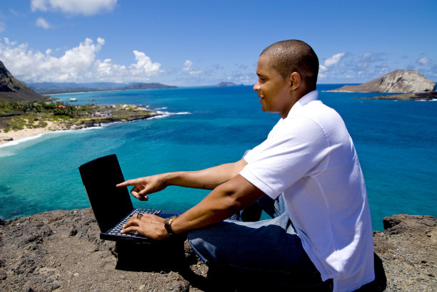 使用笔记本电脑的悬崖上的人图片下载